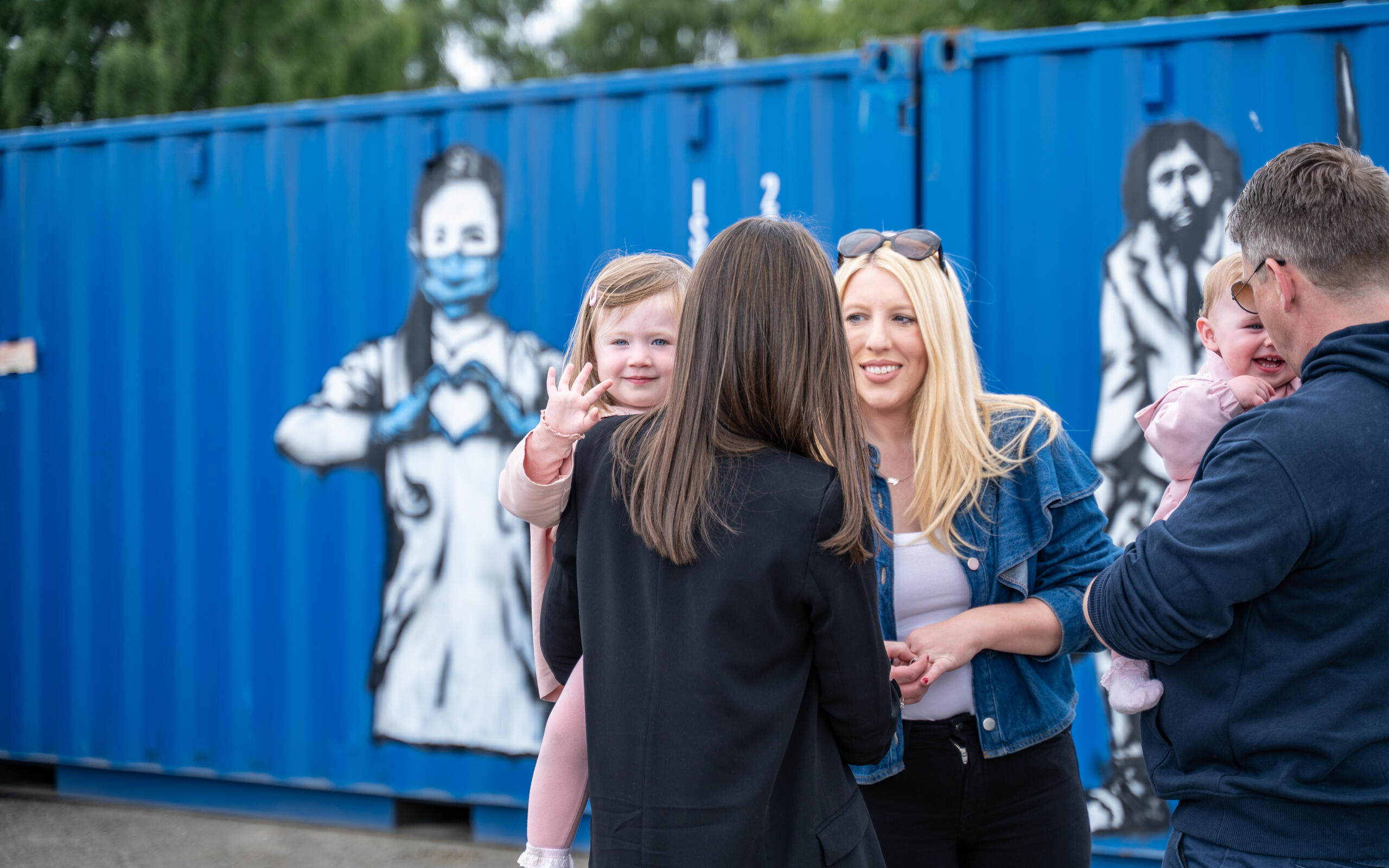Group of friends visiting the Rebel Bear street art exhibition at Boxxs Self Storage, a unique open-air gallery in Central Scotland